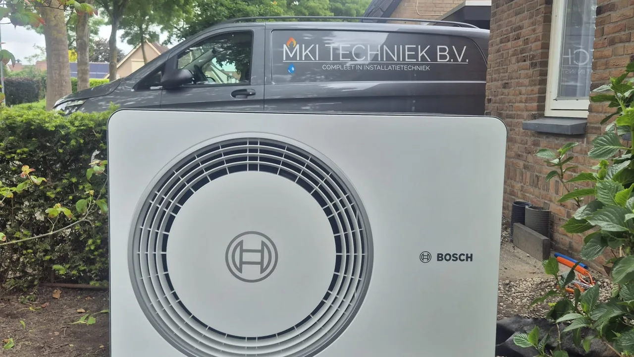 Bosch warmtepomp buitenunit, geïnstalleerd door MKI-Techniek met bedrijfsbus op de achtergrond