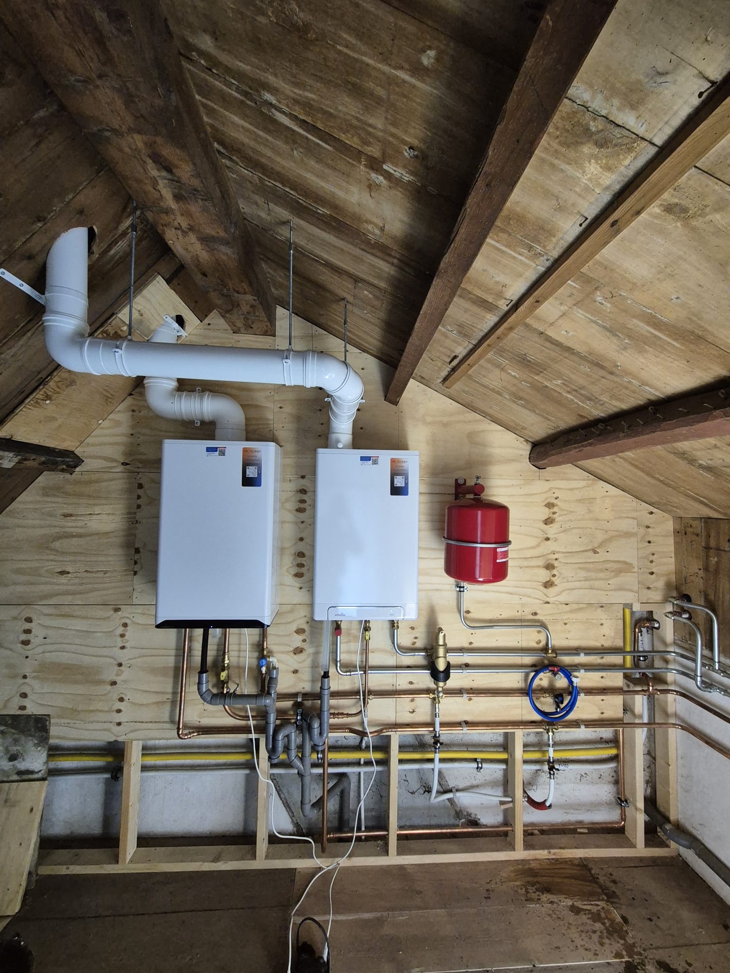 Twee CV-ketels naast elkaar geplaatst in houten zolderconstructie van B&B