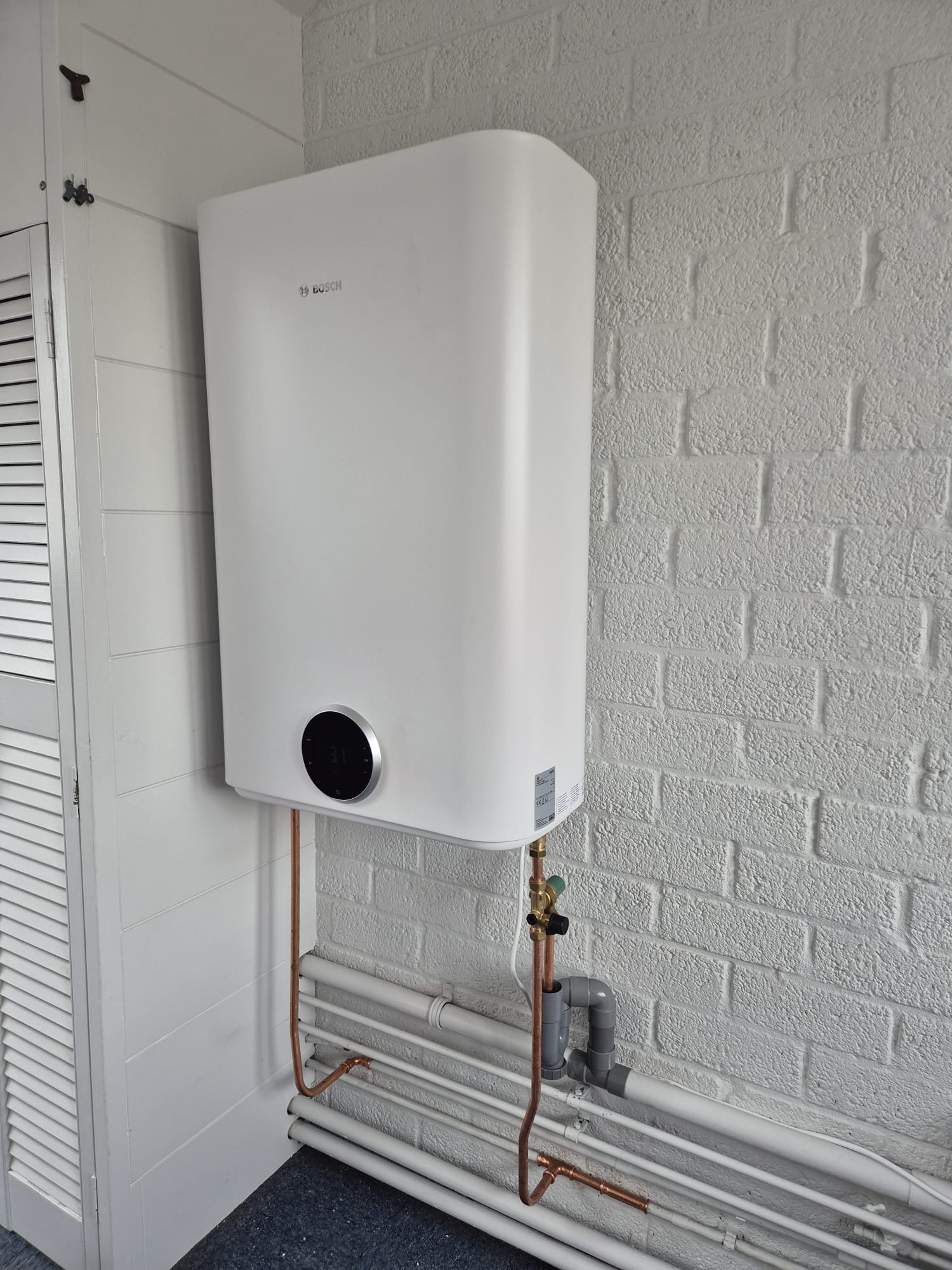 Nieuwe Bosch HR-ketel met koperleidingen netjes gemonteerd in authentiek rietgedekt pand