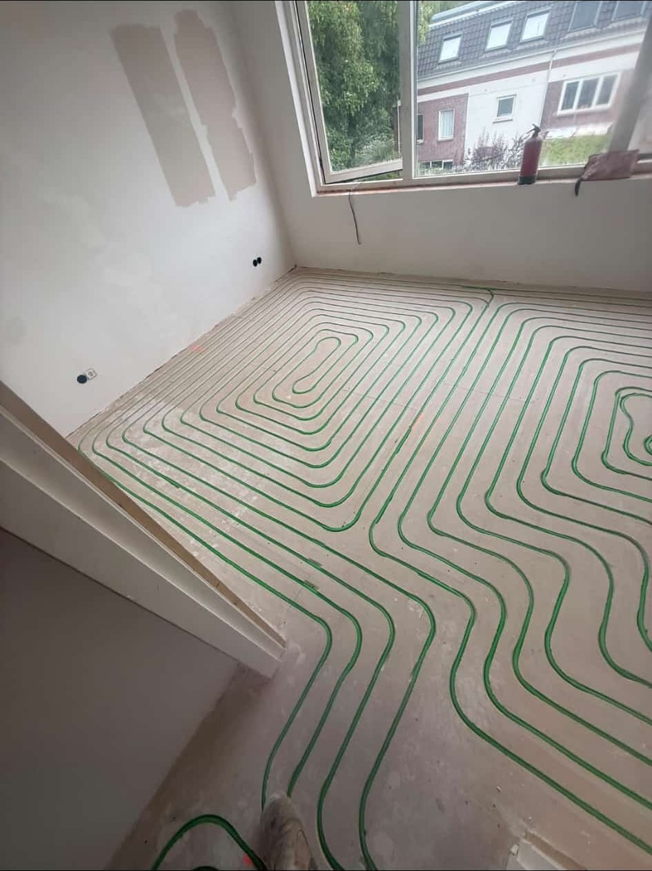 Ingefreesde vloerverwarming met groene leidingen in slaapkamer van woning in Utrecht