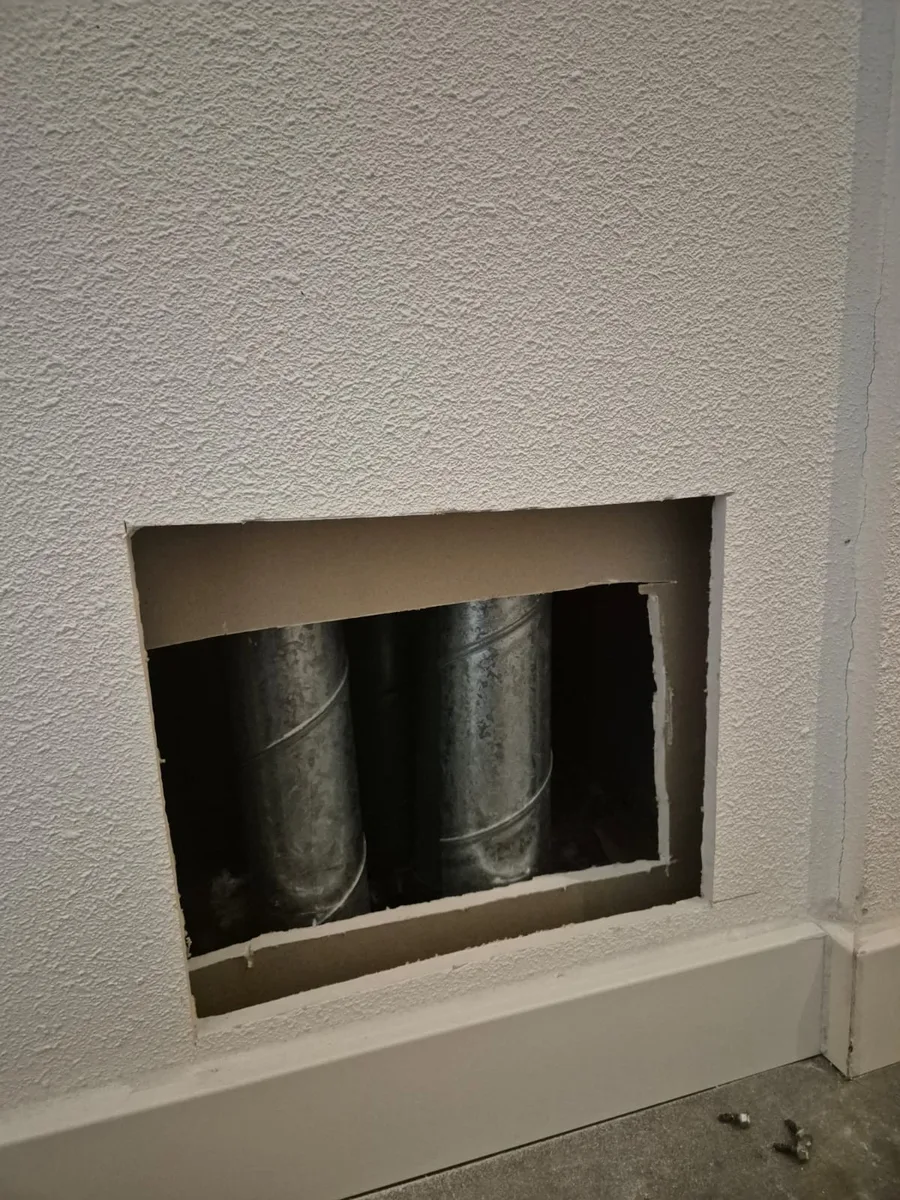 Zorgvuldig geopende wand met de bestaande rookgaskanalen zichtbaar tijdens renovatie